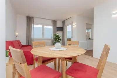 a dining room and living room with a table and chairs at Residence Haus Heinrich in Montagna