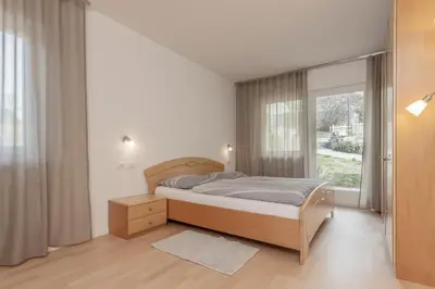 a bedroom with a bed and a large window at Residence Haus Heinrich in Montagna