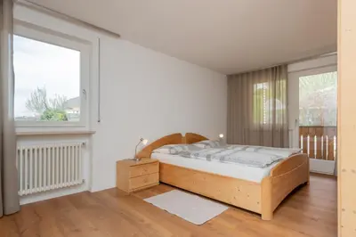 a bedroom with a wooden bed and a window at Residence Haus Heinrich in Montagna