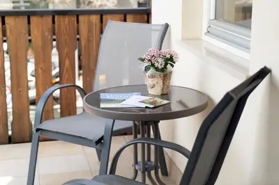a table and two chairs with a plant on a balcony at Residence Haus Heinrich in Montagna