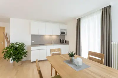 a kitchen and dining room with a wooden table at Residence Haus Heinrich in Montagna