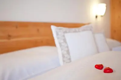 two hearts sitting on top of a bed at Lienharterhof in Monguelfo