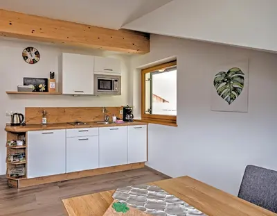 a kitchen with white cabinets and a table at Moarhof in Oberbozen in Soprabolzano