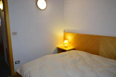 a bedroom with a bed and a lamp on a table at Casa Maddalena in Canazei