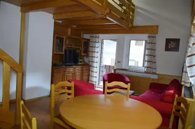 a dining room with a table and a couch at Casa Maddalena in Canazei
