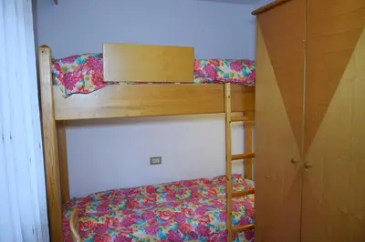 two bunk beds in a room with a bed at Casa Maddalena in Canazei