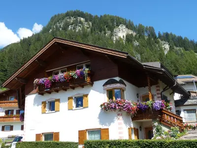 a house with flower boxes on the side of it at Cesa Paula in Selva di Val Gardena