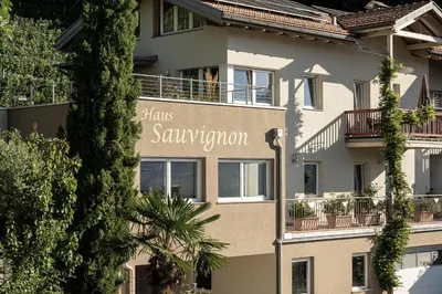 a building with a sign that says hairs saviour at Haus Sauvignon in Cortaccia