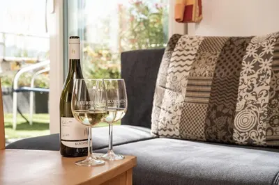 a bottle of wine and a glass on a table at Haus Sauvignon in Cortaccia
