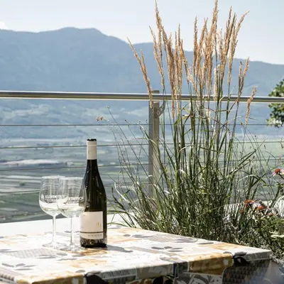 a bottle of wine sitting on a table with a glass at Haus Sauvignon in Cortaccia