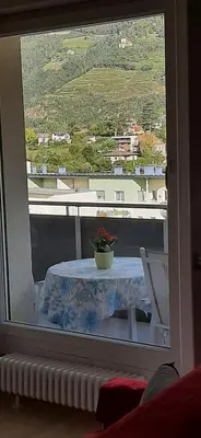 a table with a potted plant on a balcony at Merano Panoramablick ruhig gelegen in Merano
