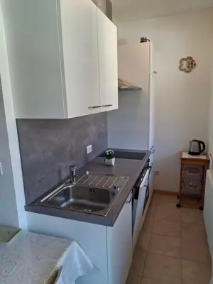 a kitchen with a stainless steel sink and white cabinets at Merano Panoramablick ruhig gelegen in Merano