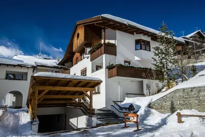 a white building with snow on the ground at Residence A Val in San Cassiano