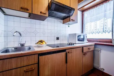 a kitchen with a sink and a microwave at Residence A Val in San Cassiano