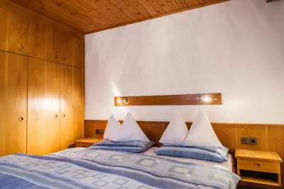 a bedroom with a bed with blue and white pillows at Residence A Val in San Cassiano