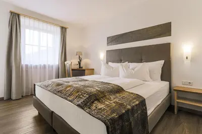 a hotel room with a large bed and a window at Residence Kronenwirt in Parcines