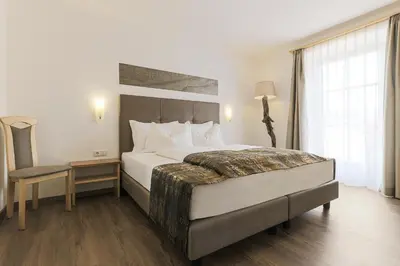 a hotel room with a large bed and a window at Residence Kronenwirt in Parcines