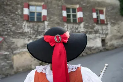 a person wearing a black hat with a red ribbon at Residence Kronenwirt in Parcines