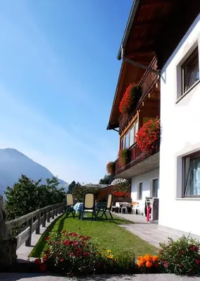 two chairs sitting in the grass next to a building at Residence Lastei in Ortisei