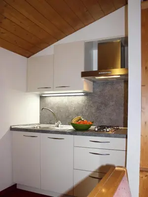 a kitchen with white cabinets and a sink at Residence Lastei in Ortisei