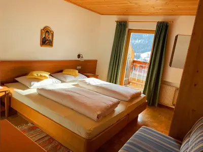 a bedroom with two beds and a window at Residence Lastei in Ortisei