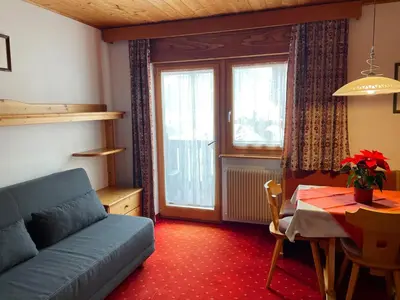 a living room with a blue couch and a table at Residence Lastei in Ortisei