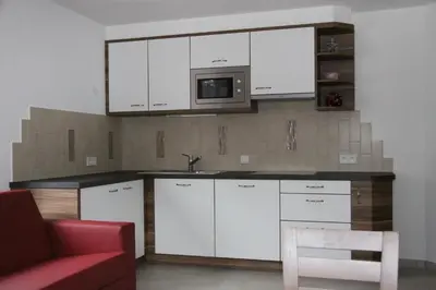 a kitchen with white cabinets and a microwave at Apartments Rusctlea in Selva di Val Gardena