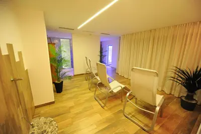 a waiting room with white chairs and a plant at Apartments Rusctlea in Selva di Val Gardena