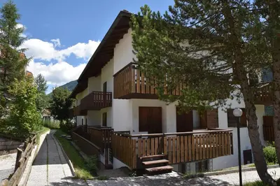 a house with wooden balconies on the side of it at Il cirmolo in Vigo di Fassa