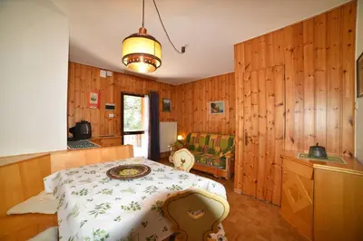 a bedroom with wooden walls and a bed in a room at Il cirmolo in Vigo di Fassa