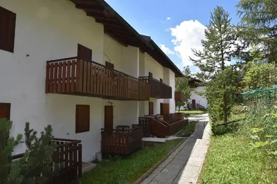 a building with wooden balconies on the side of it at Il cirmolo in Vigo di Fassa