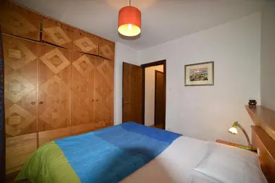 a bedroom with a bed with blue and green sheets at Il cirmolo in Vigo di Fassa