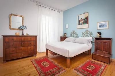 a bedroom with a bed and a dresser and a mirror at Casa Al Duomo-Nel cuore storico di Merano in Merano