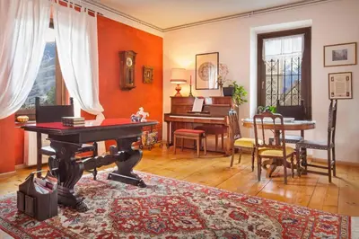 a living room with a piano and a table at Casa Al Duomo-Nel cuore storico di Merano in Merano