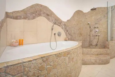 a bathroom with a bath tub and a shower at Casa Al Duomo-Nel cuore storico di Merano in Merano