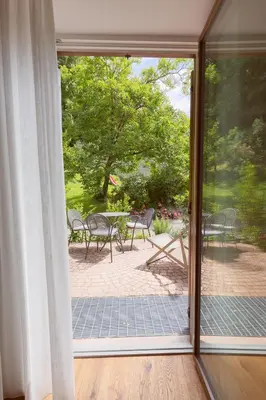 an open door to a patio with a table and chairs at BNB Garni Kreithof in Caldaro
