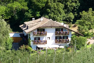 a white house with balconies and people on it at BNB Garni Kreithof in Caldaro