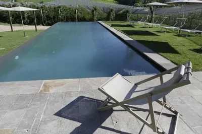a chair sitting next to a swimming pool at BNB Garni Kreithof in Caldaro