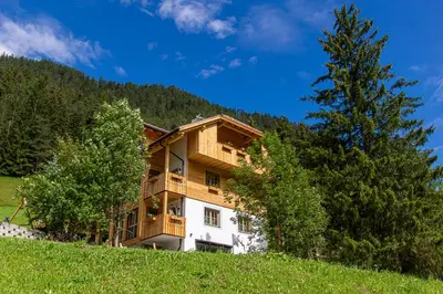 a building on top of a hill with trees at Lüch dl Jëinder in San Martino in Badia