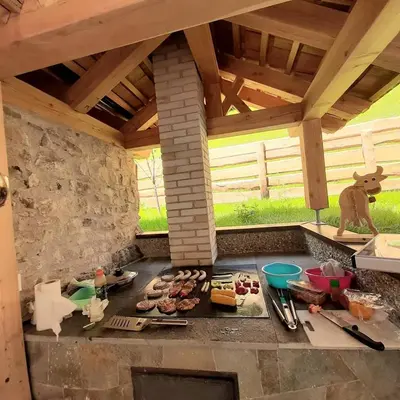 an outdoor kitchen with meat and other foods on a counter at Lüch dl Jëinder in San Martino in Badia