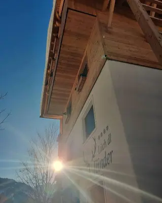 a house with the sun shining on the side of it at Lüch dl Jëinder in San Martino in Badia