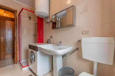 a bathroom with a sink and a washing machine at Condominio Le Coste in Falcade