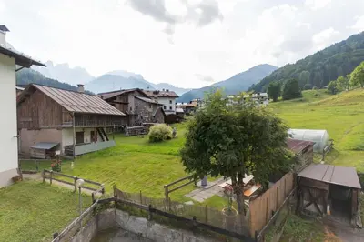 a view of a village with houses and a tree at Condominio Le Coste in Falcade