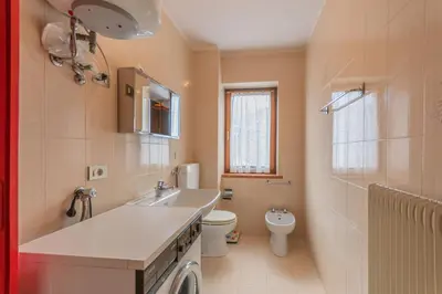 a bathroom with a sink and a toilet at Condominio Le Coste in Falcade