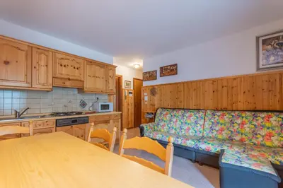 a kitchen with a couch and a table in it at Condominio Le Coste in Falcade