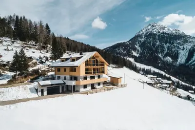 a house on top of a snow covered mountain at Sartu Apartments in San Vigilio Di Marebbe