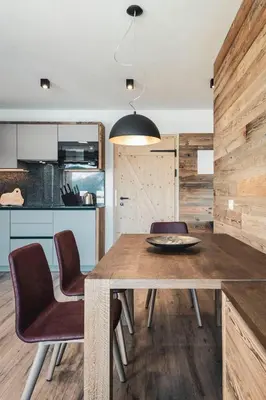 a dining room with a wooden table and chairs at Sartu Apartments in San Vigilio Di Marebbe