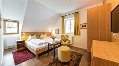 a hotel room with a bed and a table at Hotel Brückenwirt in Novacella
