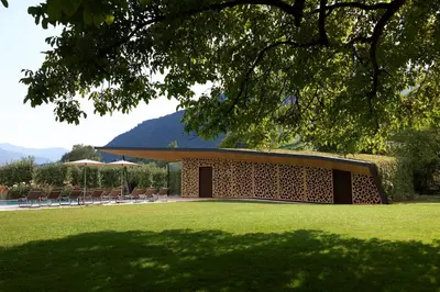 a building in a park with chairs and a lawn at Hotel Brückenwirt in Novacella