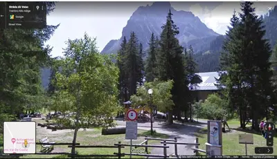 a park with trees and a mountain in the background at Appartamento MARMOLADA - CANAZEI in Canazei